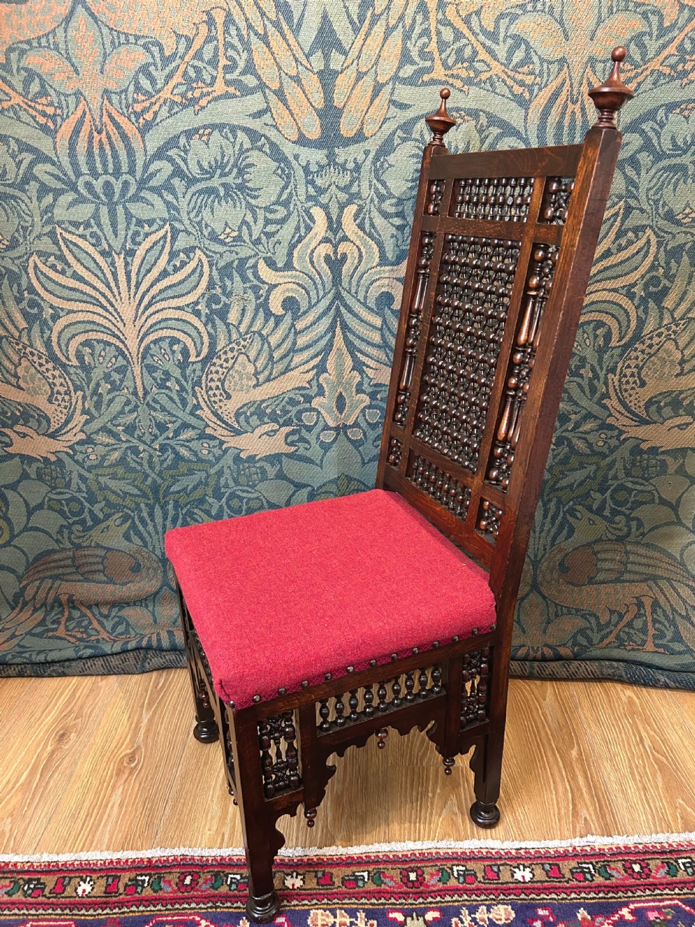 A pair of dark wood Cairene side chairs featuring turned bobbin mashrabiya latticework on the backrests and lower aprons, topped with corner finials and fitted with red wool upholstered seats. View IV