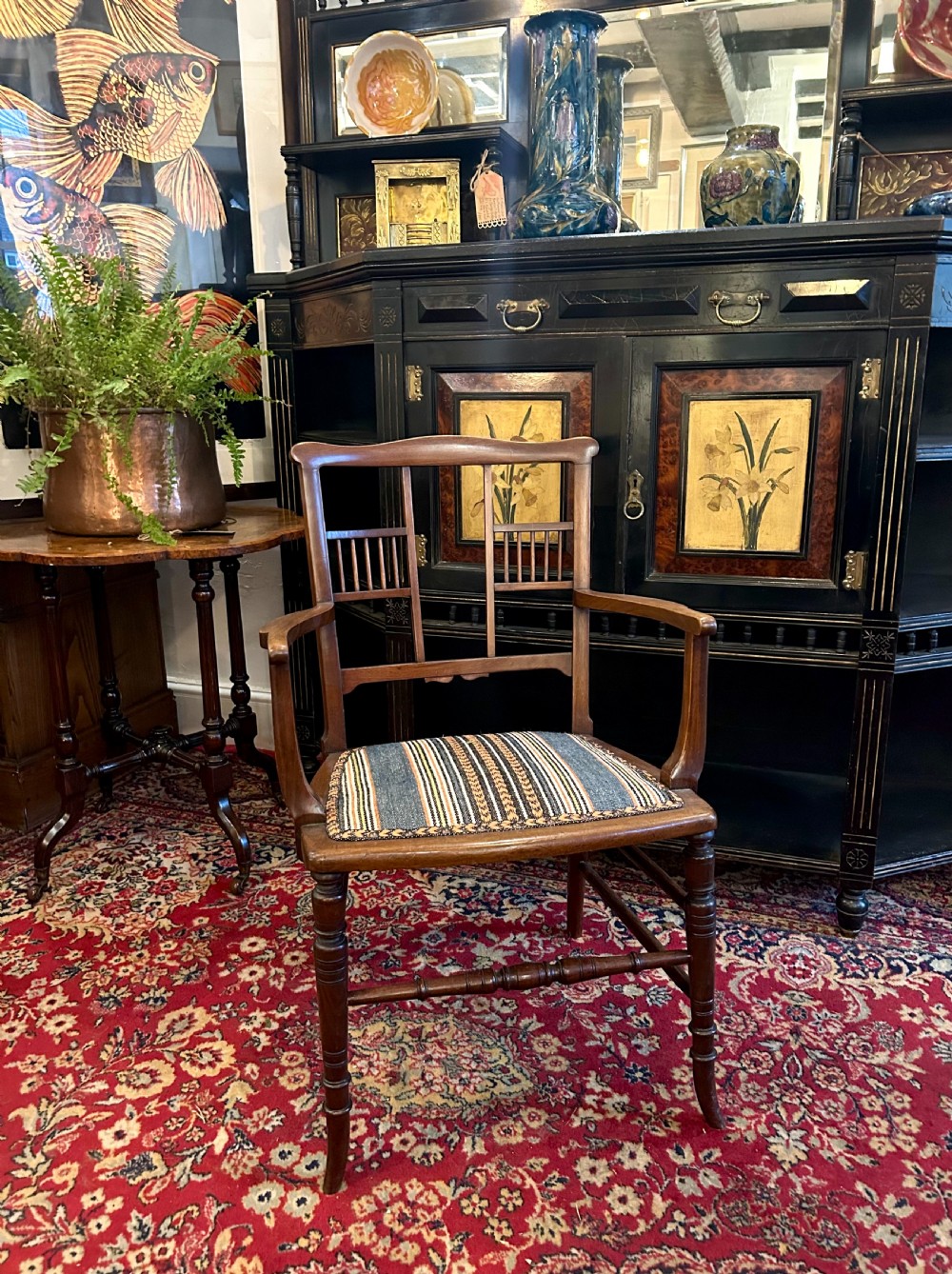 An Aesthetic Movement timber armchair with turned legs, spindle back details, curved armrests, and a striped woven fabric seat. View VII