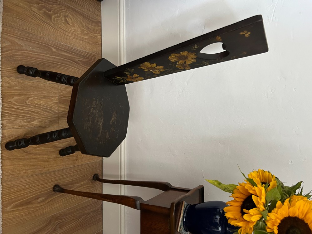 A dark wood Welsh spinning chair featuring a tall narrow backrest decorated with hand-painted yellow flowers and a heart cutout above a hexagonal seat and turned legs. View II