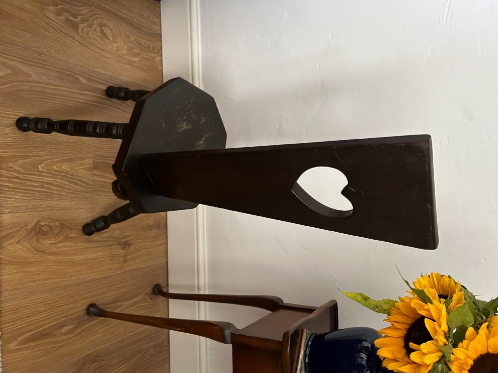 A dark wood Welsh spinning chair featuring a tall narrow backrest decorated with hand-painted yellow flowers and a heart cutout above a hexagonal seat and turned legs. View IV