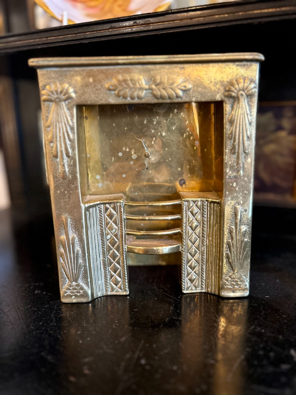 A Victorian brass tradesmans sample fireplace featuring embossed foliage details, a central grate, and a curved fender. View III