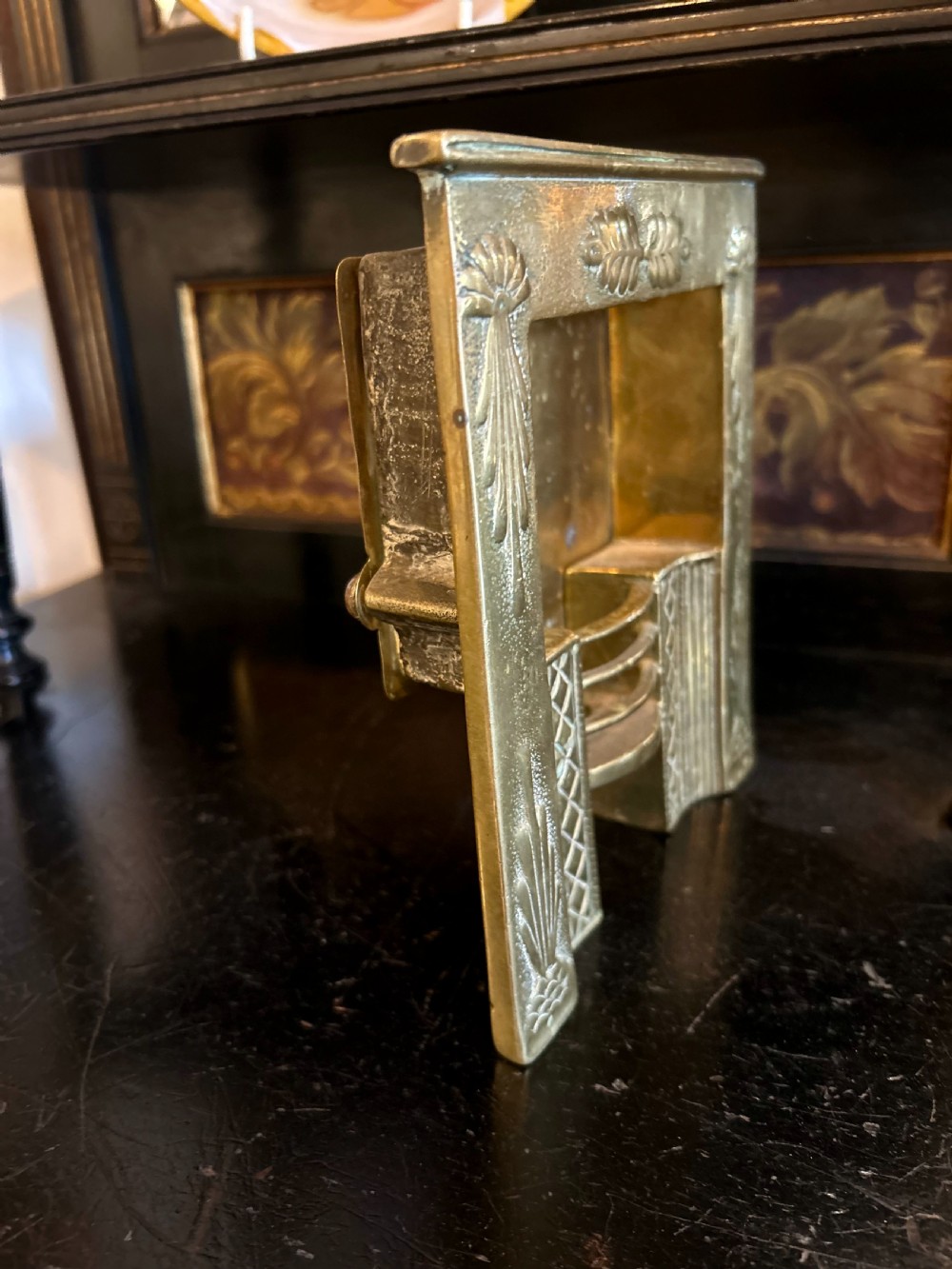 A Victorian brass tradesmans sample fireplace featuring embossed foliage details, a central grate, and a curved fender. View IV