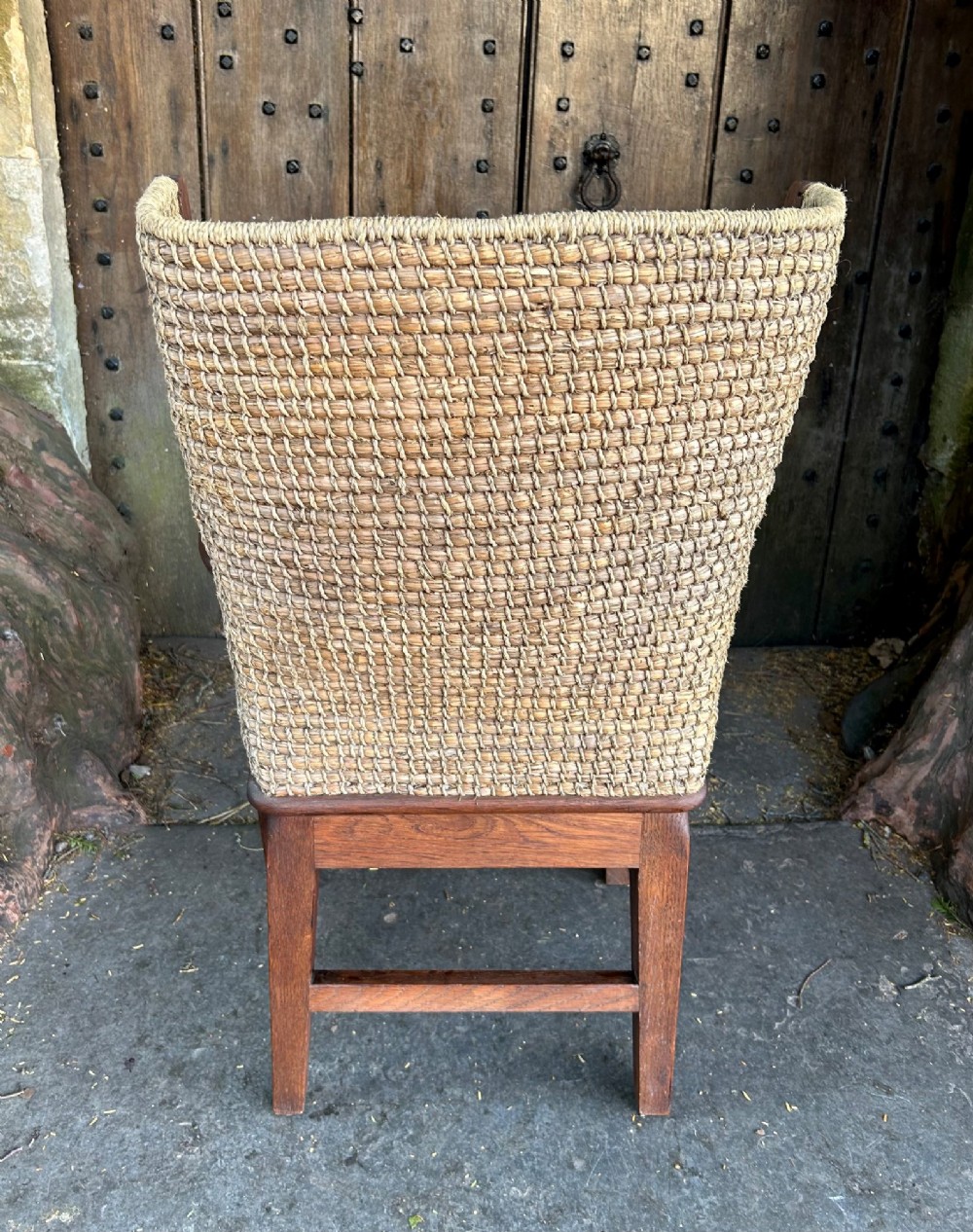 An antique Scottish Orkney armchair featuring a dark oak wood frame, scrolled arms, a drop-in rush seat, and a tall woven straw backrest. View VIII