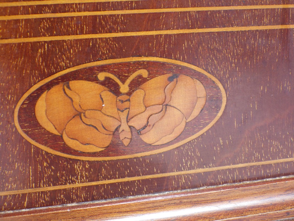 An English double fusee bracket clock crafted from dark mahogany wood with brass finials, brass column accents, marquetry inlay, and a circular white dial featuring Roman numerals. View XII