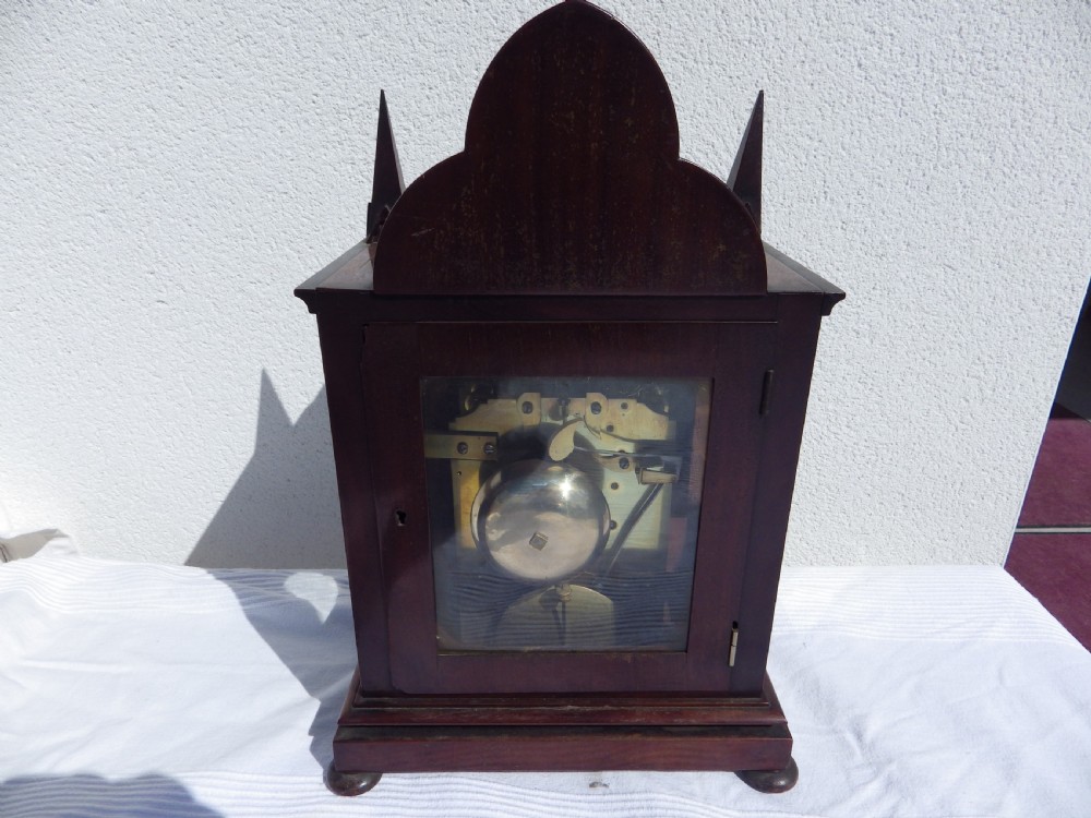 A Victorian Gothic Revival mahogany double fusee bracket clock featuring spire finials, reeded side columns, and an arched cream dial face with Roman numerals. View VII
