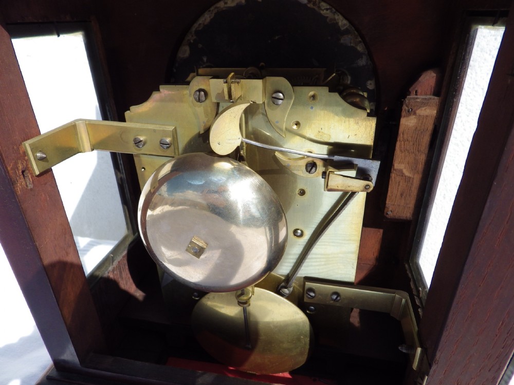 A Victorian Gothic Revival mahogany double fusee bracket clock featuring spire finials, reeded side columns, and an arched cream dial face with Roman numerals. View VIII