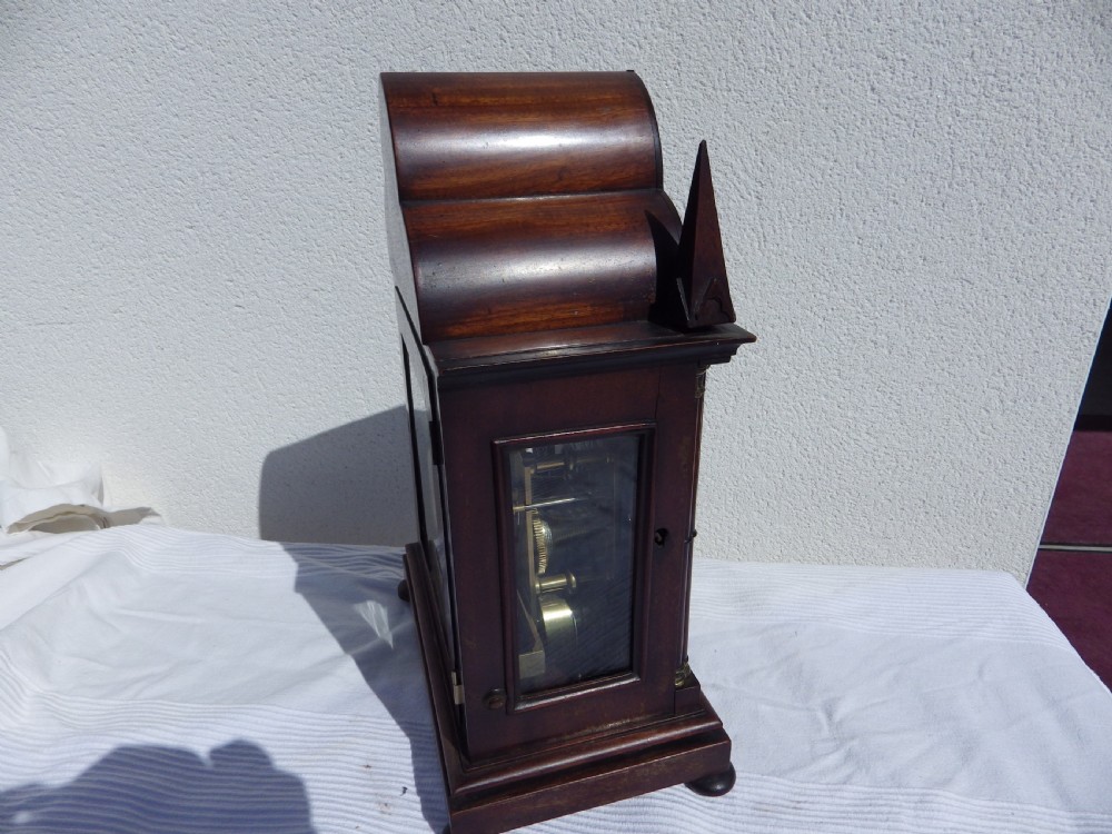 A Victorian Gothic Revival mahogany double fusee bracket clock featuring spire finials, reeded side columns, and an arched cream dial face with Roman numerals. View IX