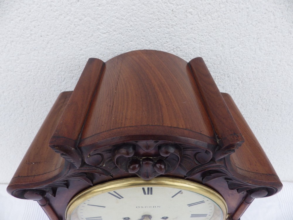 A carved mahogany English double fusee bracket clock featuring a circular cream dial with Roman numerals signed Osborn Bognor. View II