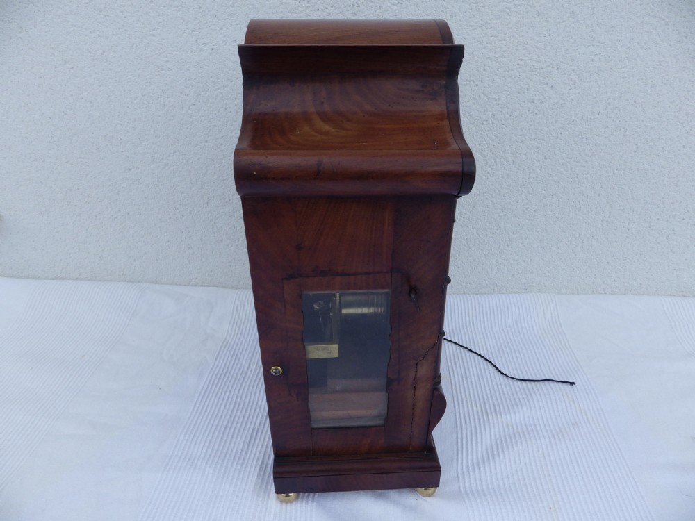 A carved mahogany English double fusee bracket clock featuring a circular cream dial with Roman numerals signed Osborn Bognor. View VIII