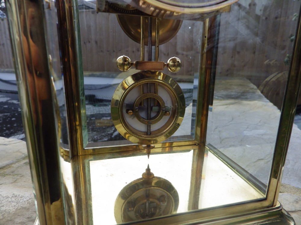 An antique brass four-glass regulator mantel clock featuring a white enamel dial with Roman numerals and an integrated blue moon-phase display. View III