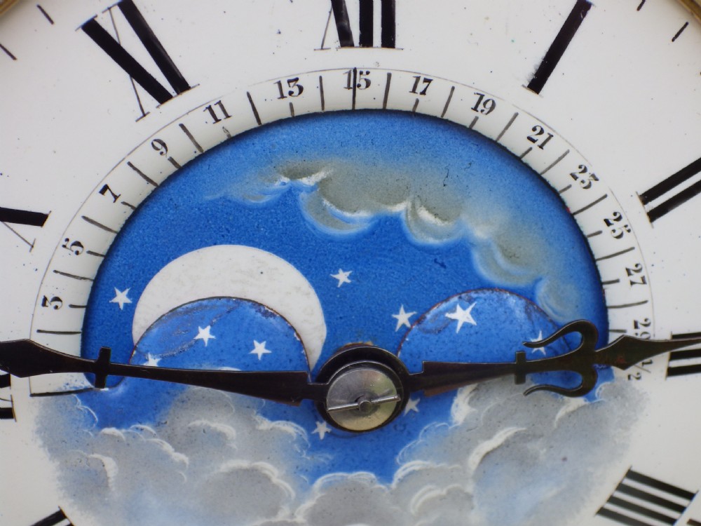 An antique brass four-glass regulator mantel clock featuring a white enamel dial with Roman numerals and an integrated blue moon-phase display. View VIII