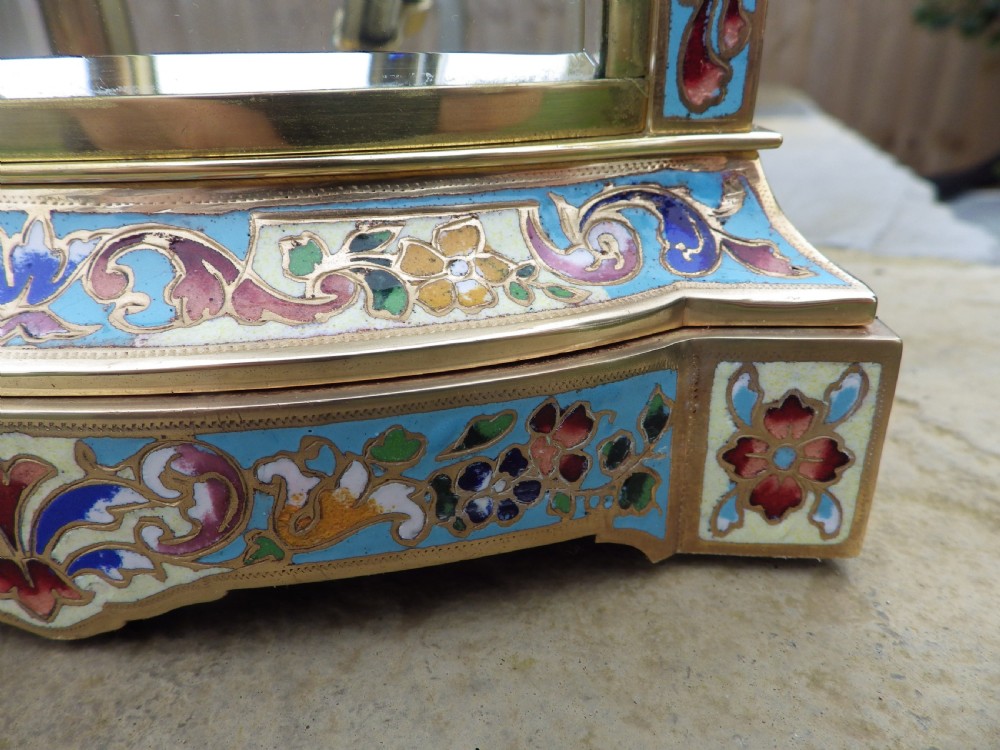 A late 19th-century French four-glass mantel clock featuring a brass frame, curved bow-front glass panel, polychrome champleve enamel borders, and a white porcelain dial with blue Arabic numerals. View IX