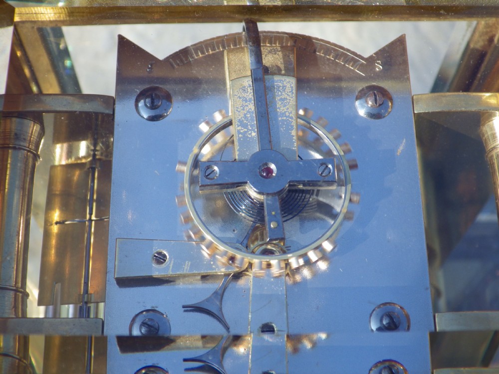 A French gilt brass giant repeating carriage clock featuring a white enamel dial with Roman numerals, an engraved brass mask, bevelled glass panels, and a hinged top handle. View VII