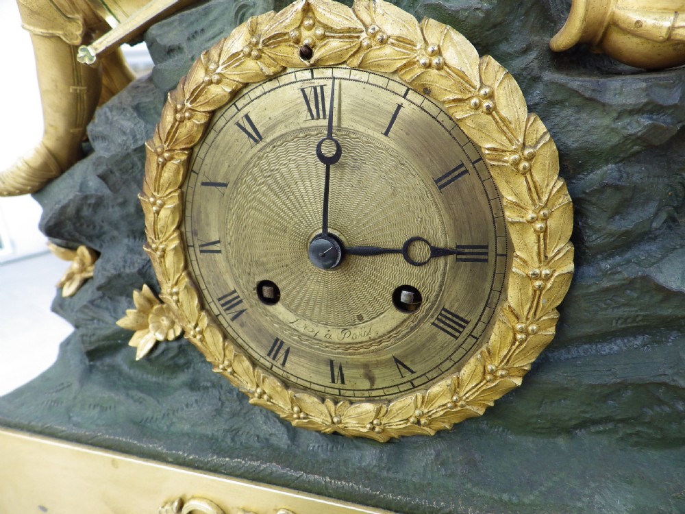 An antique French Empire gilt and patinated bronze mantel clock featuring sculpted figures of medieval soldiers above an ornamented base. View III