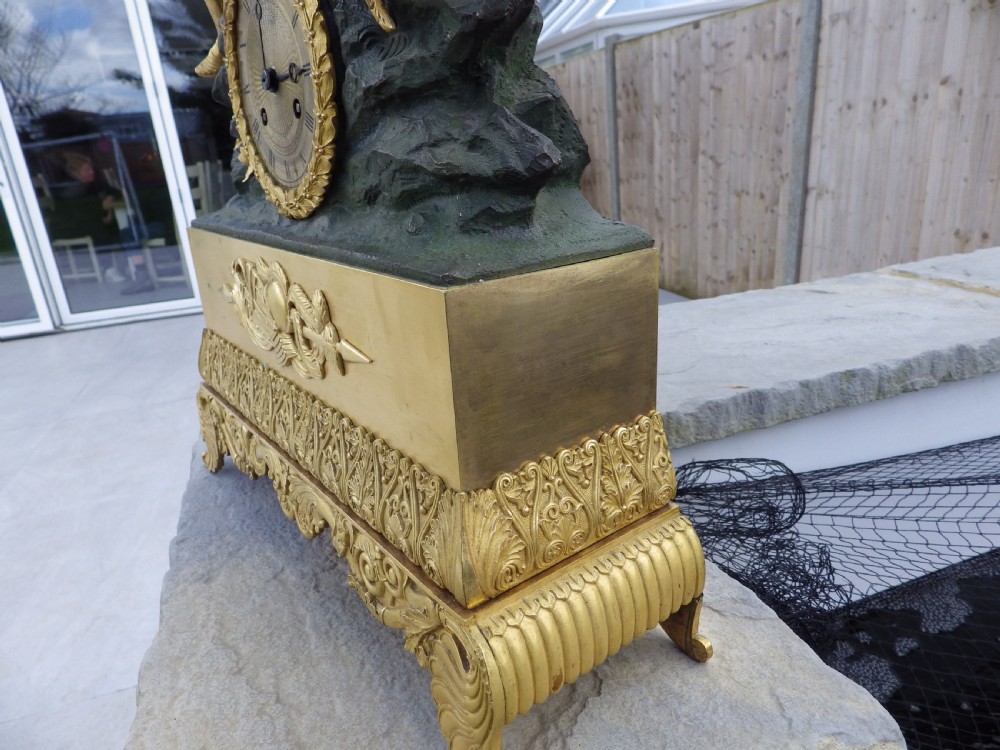 An antique French Empire gilt and patinated bronze mantel clock featuring sculpted figures of medieval soldiers above an ornamented base. View V