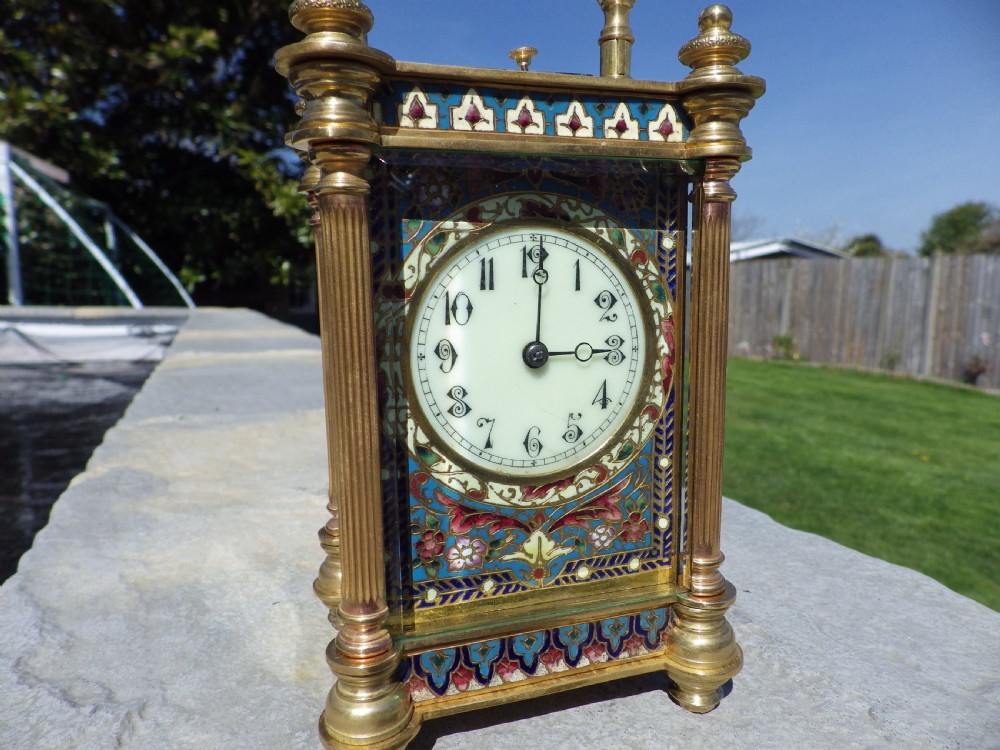 A nineteenth-century French gilt brass carriage clock decorated with polychrome champleve enamel panels and a white dial with Arabic numerals. View V