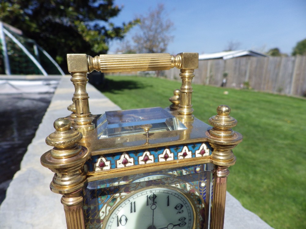 A nineteenth-century French gilt brass carriage clock decorated with polychrome champleve enamel panels and a white dial with Arabic numerals. View VI
