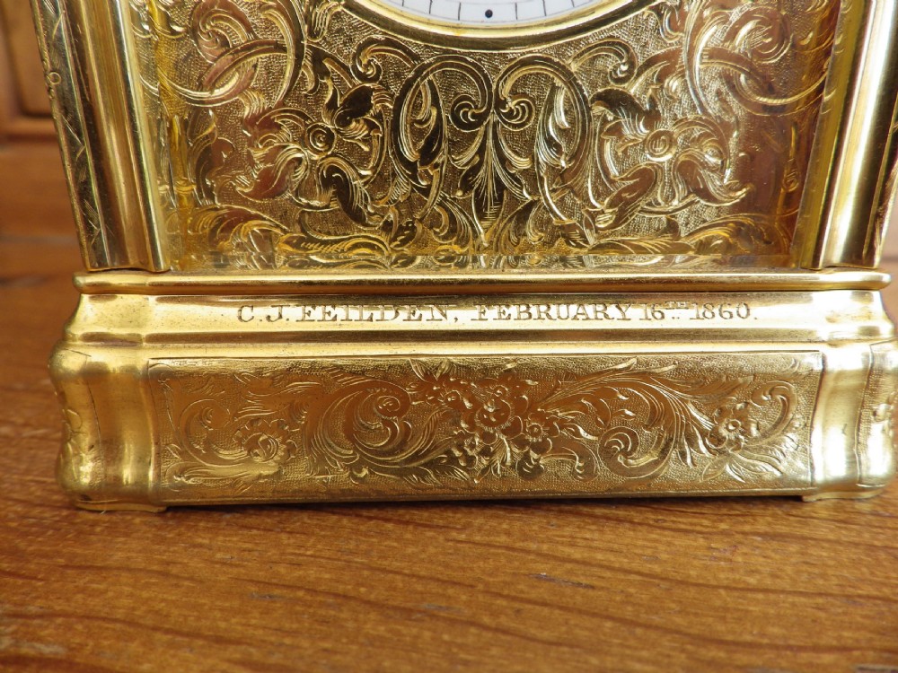 An engraved gilt brass French repeating carriage clock with a white enamel dial, Roman numerals, and a top handle. View VIII