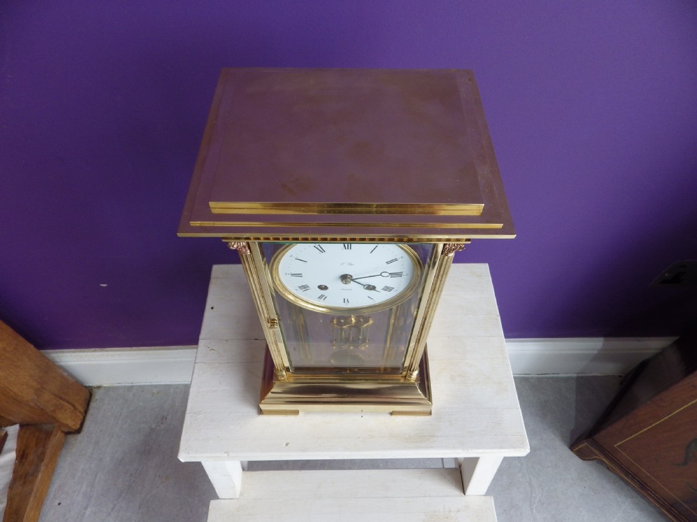 A brass French crystal regulator mantle clock featuring four bevelled glass sides, fluted corner columns, a white enamel dial with Roman numerals, and a visible pendulum. View II