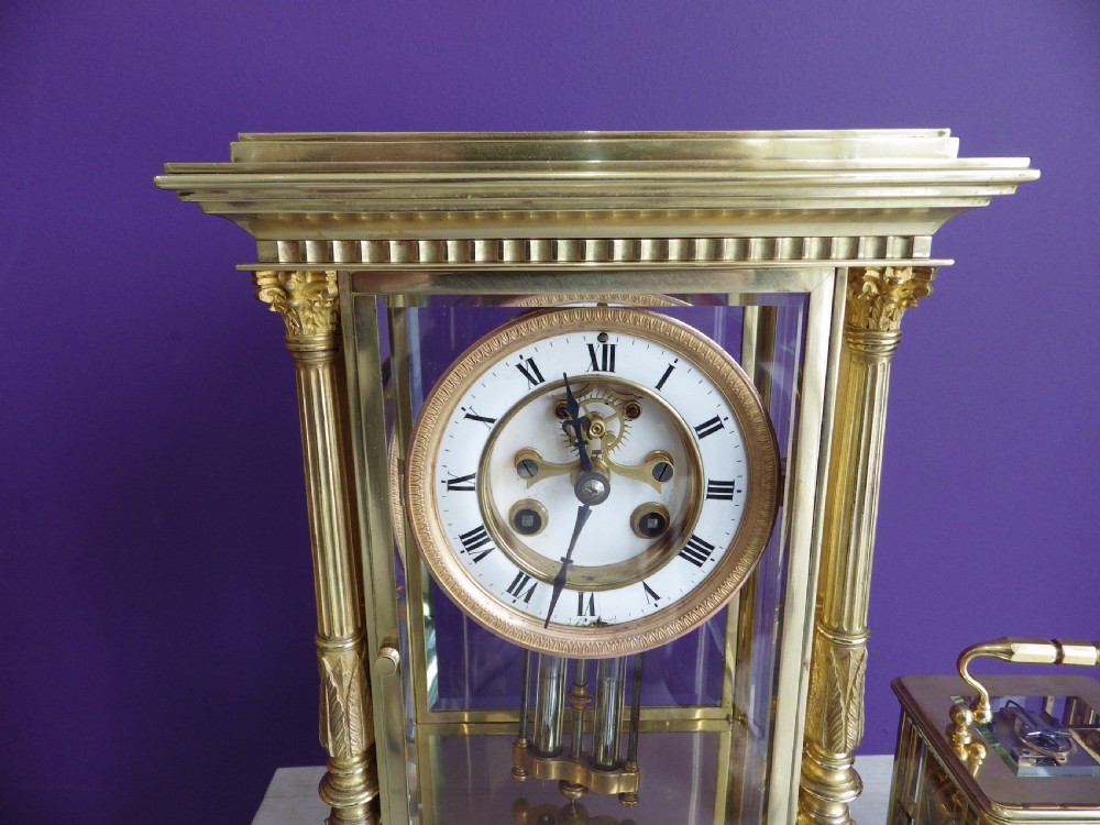 A nineteenth-century French gilt brass crystal regulator mantel clock featuring four bevelled glass sides, fluted corner columns, an enamel dial with Roman numerals, and a visible pendulum. View III