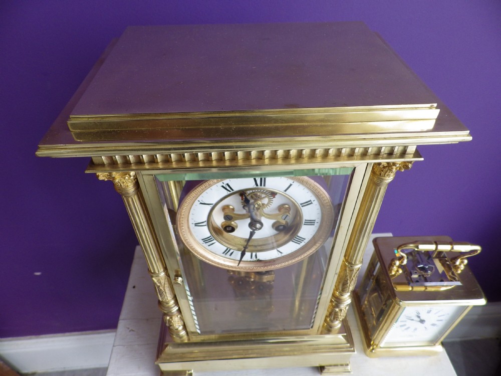 A nineteenth-century French gilt brass crystal regulator mantel clock featuring four bevelled glass sides, fluted corner columns, an enamel dial with Roman numerals, and a visible pendulum. View VI