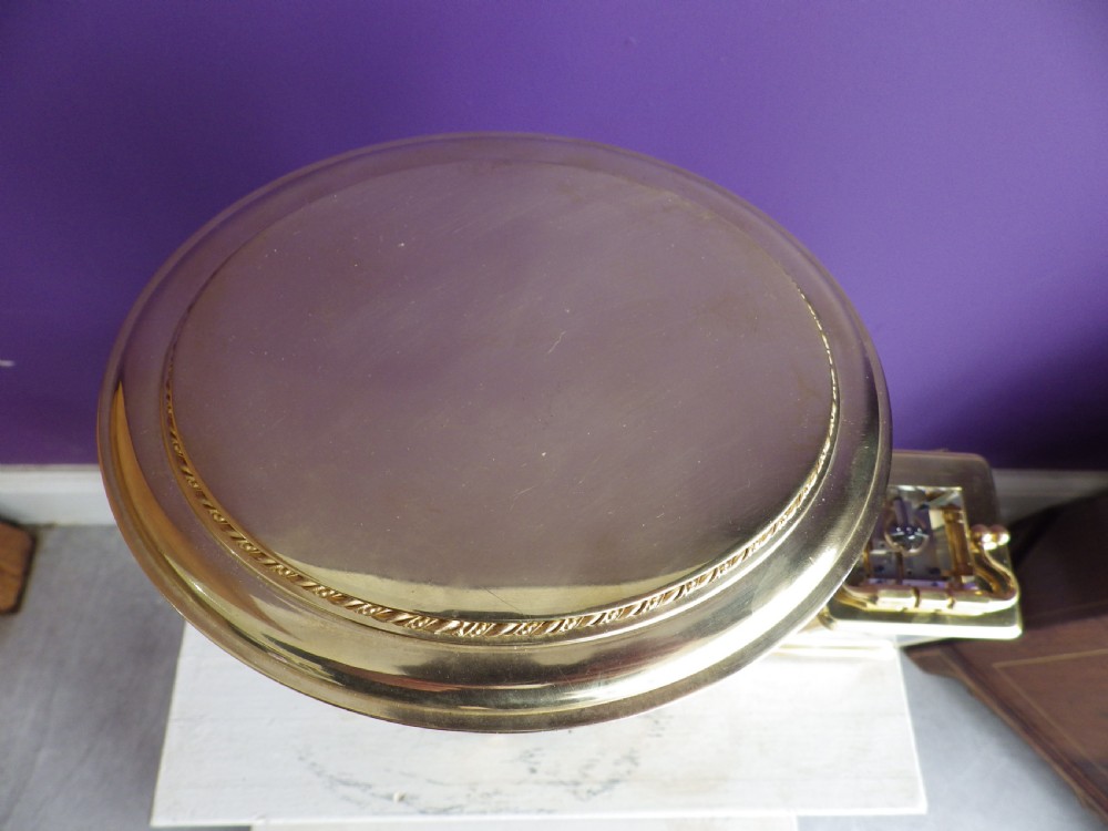 A French oval gilt brass crystal regulator clock featuring bevelled glass casing, fluted column supports, and an ornate circular dial. View VI