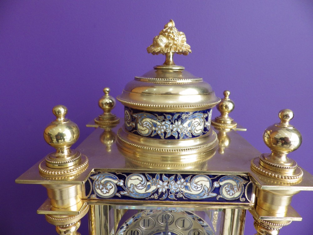 An antique French gilt brass crystal regulator clock featuring four clear glass sides, blue champleve enamel scrollwork, decorative corner columns, and an intricate dial. View IV