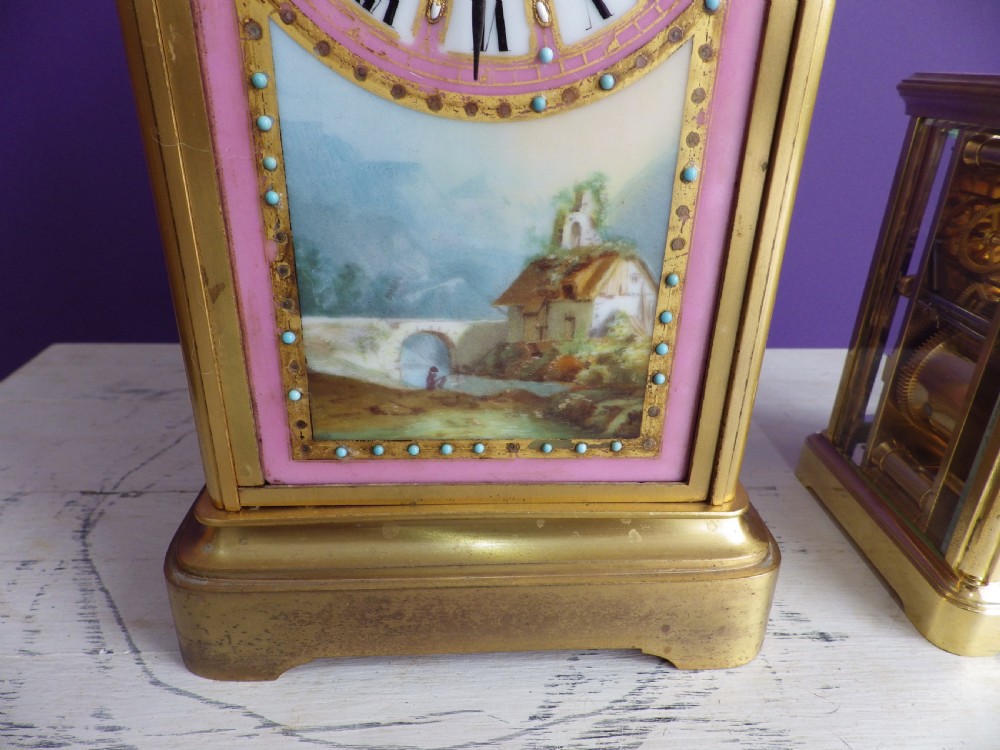A nineteenth-century French gilt brass mantel clock featuring pink hand-painted porcelain panels depicting a landscape scene. View II