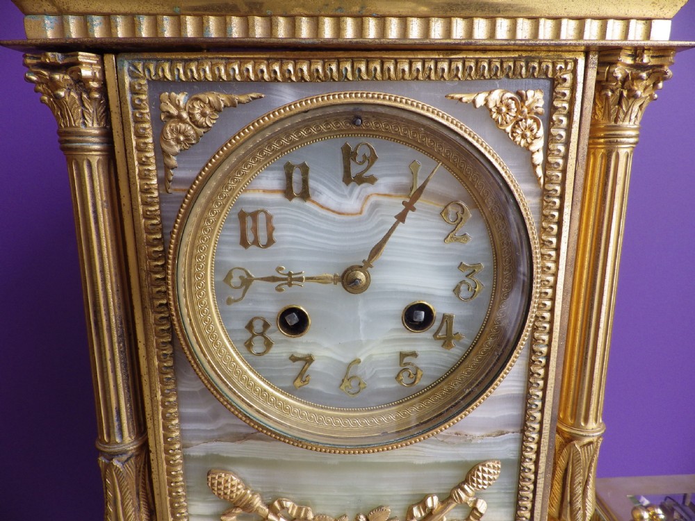 A late 19th-century French gilt bronze mantle clock featuring green onyx panels, fluted side columns, and an ornate floral mount. View III