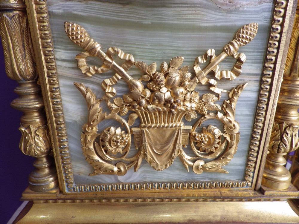 A late 19th-century French gilt bronze mantle clock featuring green onyx panels, fluted side columns, and an ornate floral mount. View IV