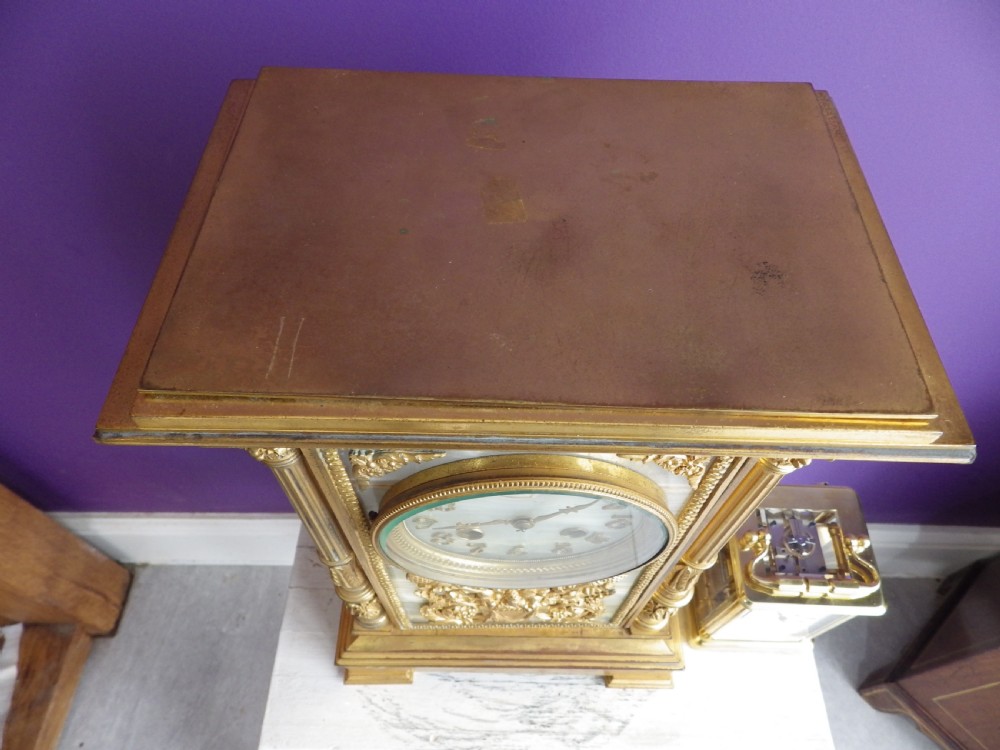 A late 19th-century French gilt bronze mantle clock featuring green onyx panels, fluted side columns, and an ornate floral mount. View IX