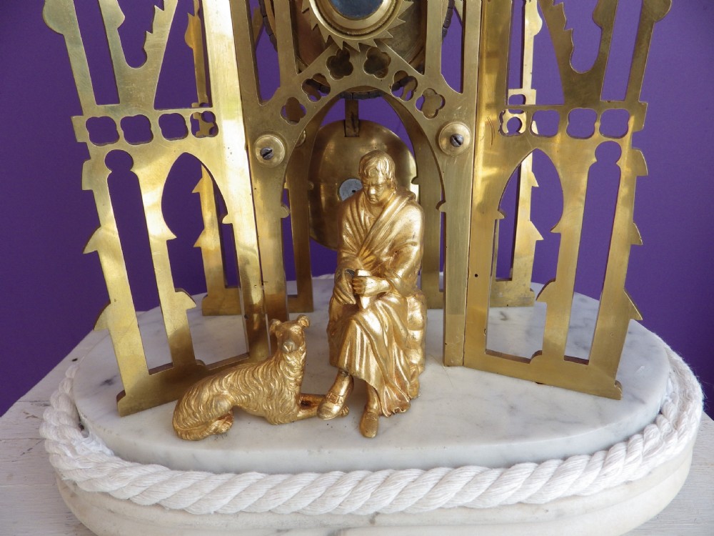 Victorian brass skeleton clock modelled after the Scott Monument featuring an openwork frame, silvered chapter ring, seated figurine, and white marble base. View II