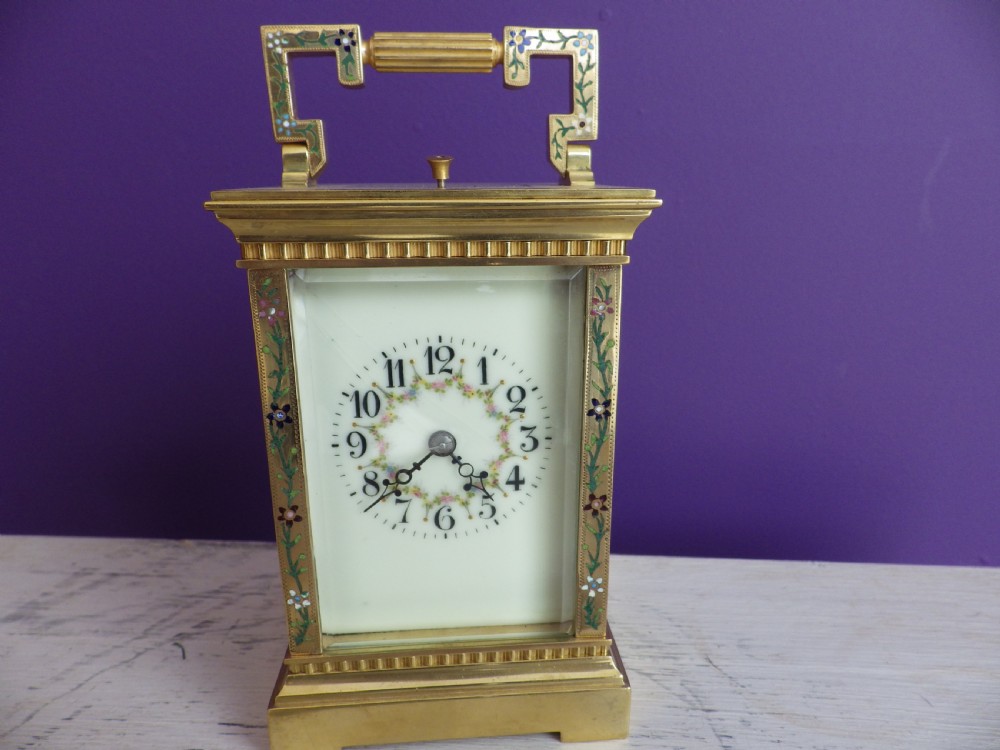 Late nineteenth-century gilt brass French carriage clock featuring polychrome floral enamel borders, a carrying handle, and an enamel dial with Arabic numerals.
