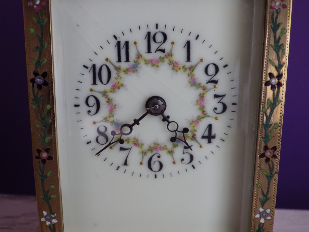 Late nineteenth-century gilt brass French carriage clock featuring polychrome floral enamel borders, a carrying handle, and an enamel dial with Arabic numerals. View II