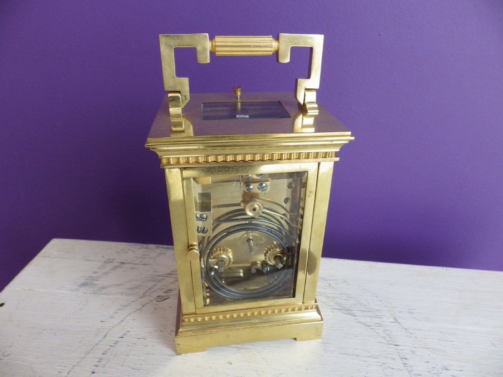 Late nineteenth-century gilt brass French carriage clock featuring polychrome floral enamel borders, a carrying handle, and an enamel dial with Arabic numerals. View VI