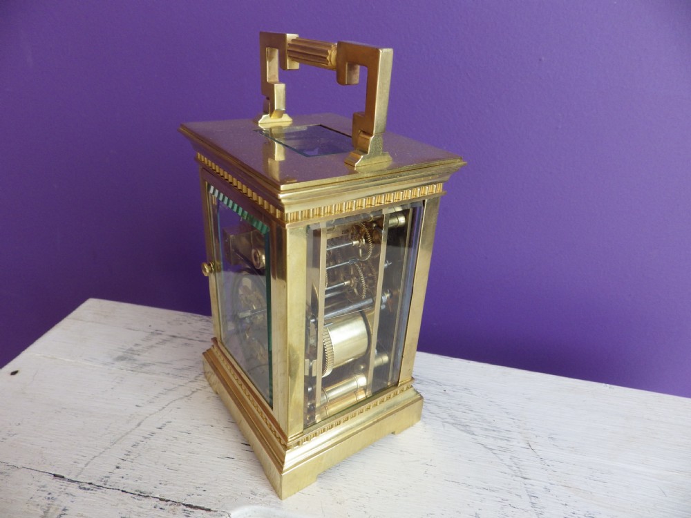 Late nineteenth-century gilt brass French carriage clock featuring polychrome floral enamel borders, a carrying handle, and an enamel dial with Arabic numerals. View VII