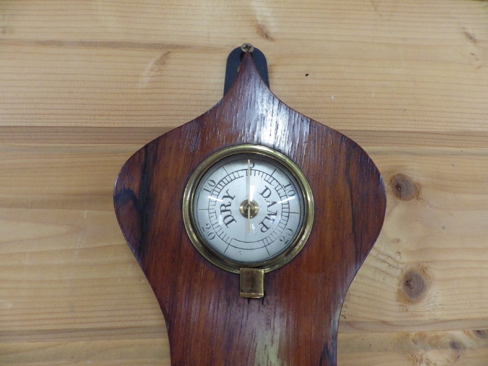 A Victorian wall-mounted mahogany banjo mercury barometer featuring a silvered dial, spirit thermometer, convex mirror, and brass fittings. View V