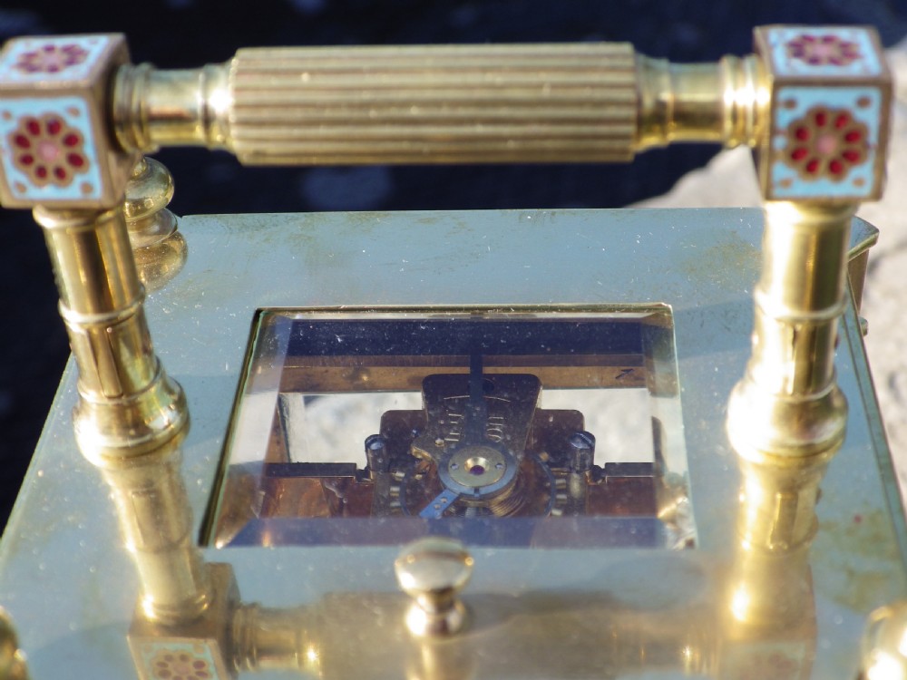 An antique French gilded brass carriage clock featuring polychrome enamel bandings, turned corner columns, and a white circular dial with Arabic numerals. View VI