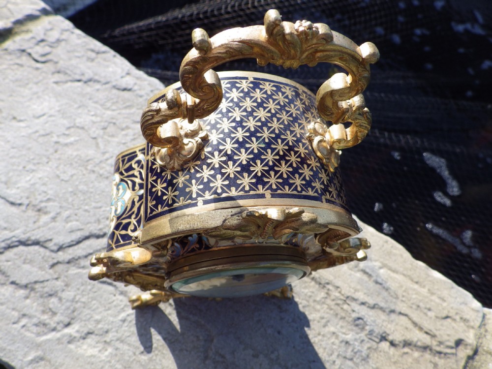 A late 19th-century French Rococo revival mantel clock crafted in gilt bronze ormolu with blue and cream champleve enamel detailing. View VII