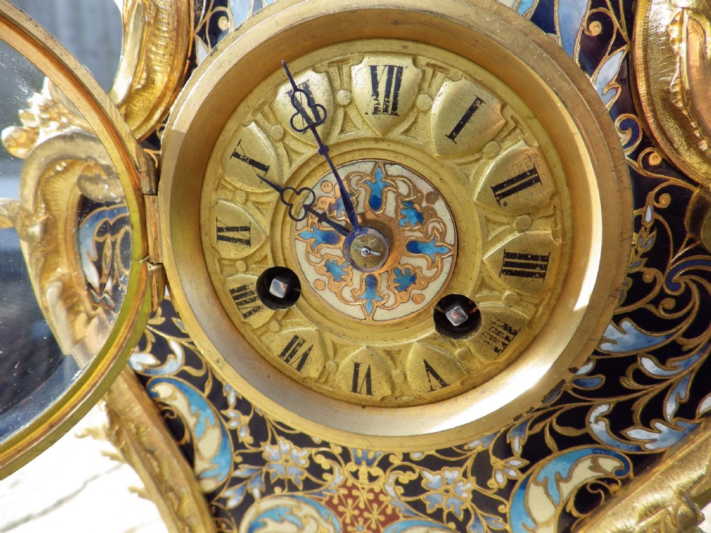 A late 19th-century French Rococo revival mantel clock crafted in gilt bronze ormolu with blue and cream champleve enamel detailing. View IX