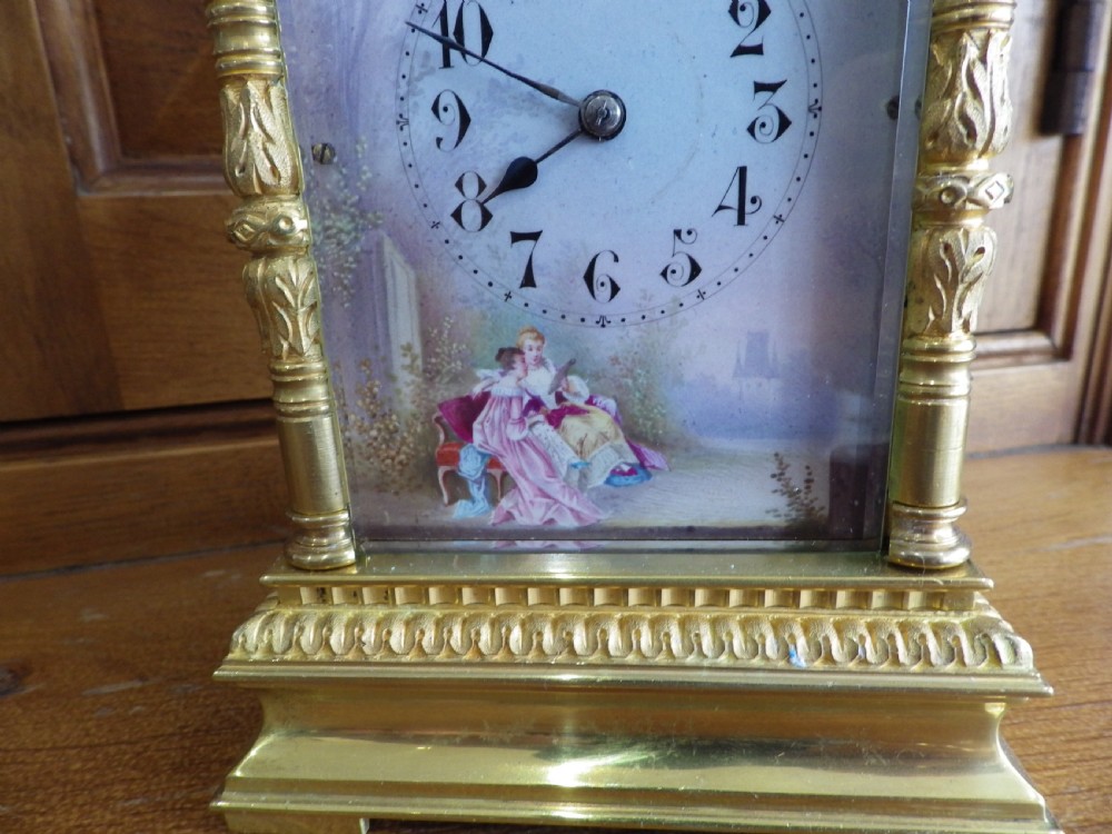 A nineteenth-century French gilt brass carriage clock featuring a top carrying handle, decorative corner columns, and hand-painted enamel panels depicting figures. View VIII