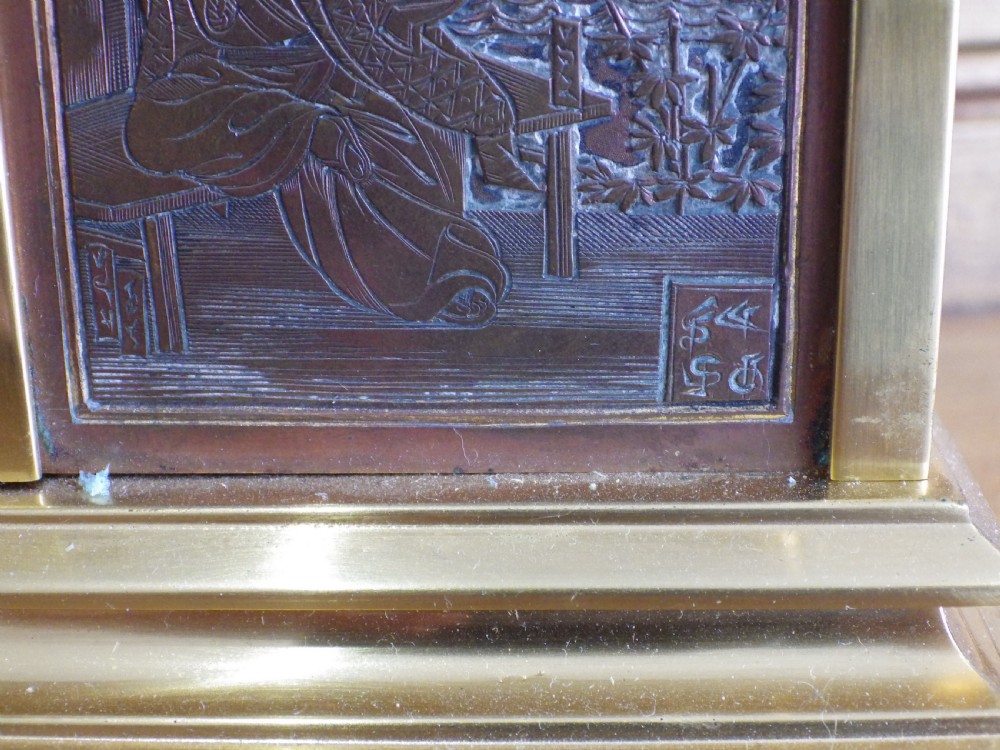 A late nineteenth-century French brass carriage clock featuring an ornate carrying handle, a circular white dial with Roman numerals, and relief-carved bronze faceplates depicting game birds amongst foliage. View V