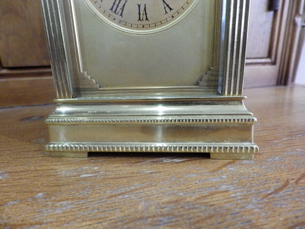A late nineteenth-century French gilt brass repeating carriage clock featuring glass panels, a carrying handle, and a dial with Roman numerals. View II