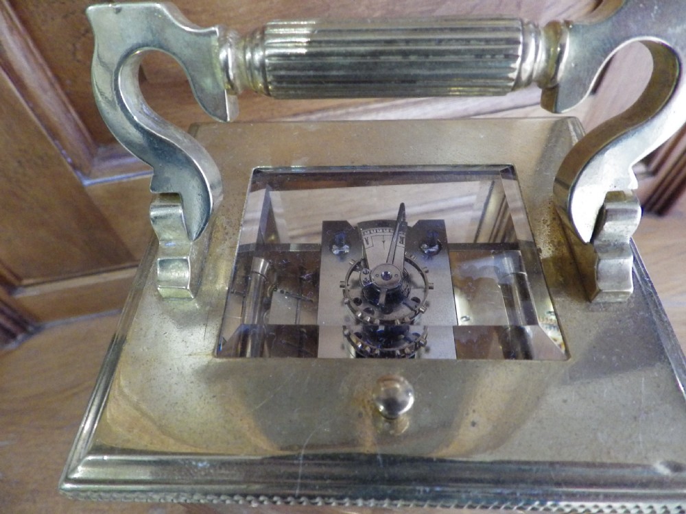A late nineteenth-century French gilt brass repeating carriage clock featuring glass panels, a carrying handle, and a dial with Roman numerals. View VII