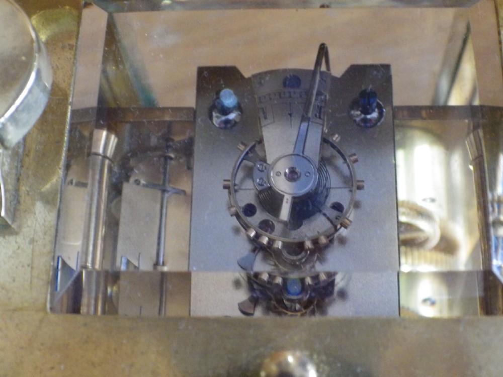 A late nineteenth-century French gilt brass repeating carriage clock featuring glass panels, a carrying handle, and a dial with Roman numerals. View IX
