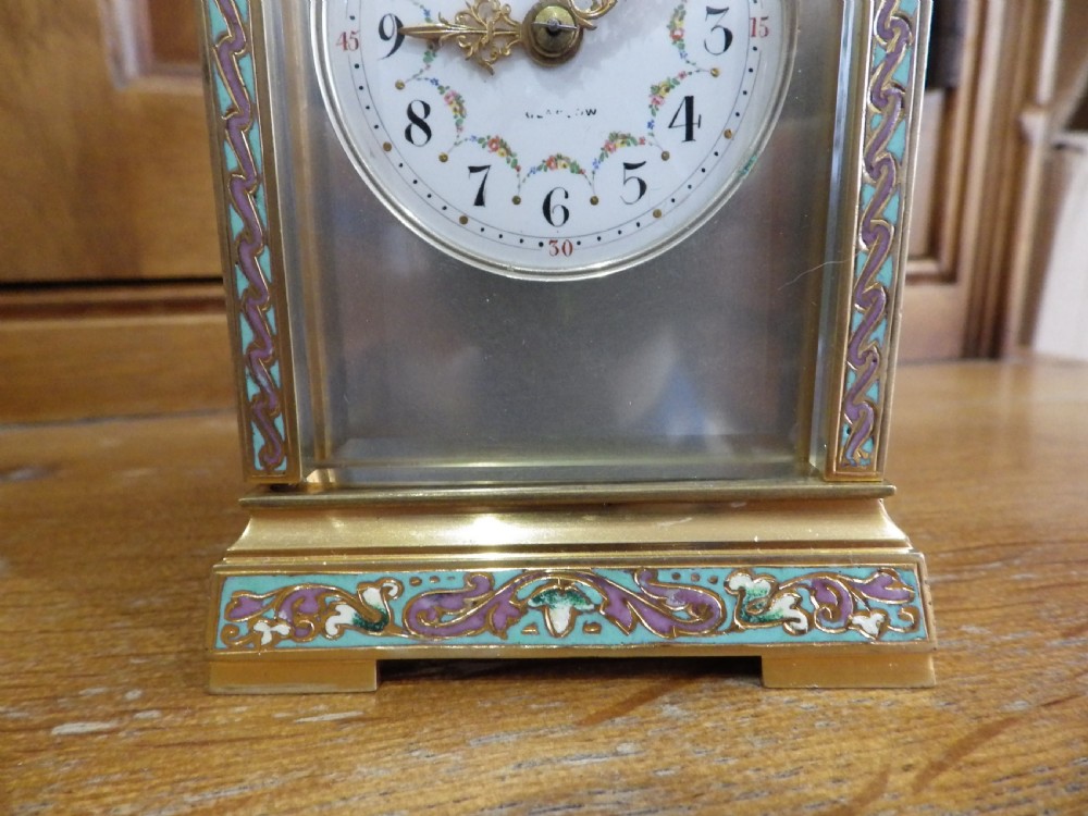 A late 19th-century French brass carriage clock featuring turquoise and purple champleve enamel borders, clear glass panels, and a painted white enamel dial. View II