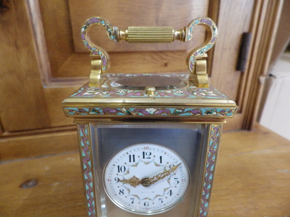 A late 19th-century French brass carriage clock featuring turquoise and purple champleve enamel borders, clear glass panels, and a painted white enamel dial. View III