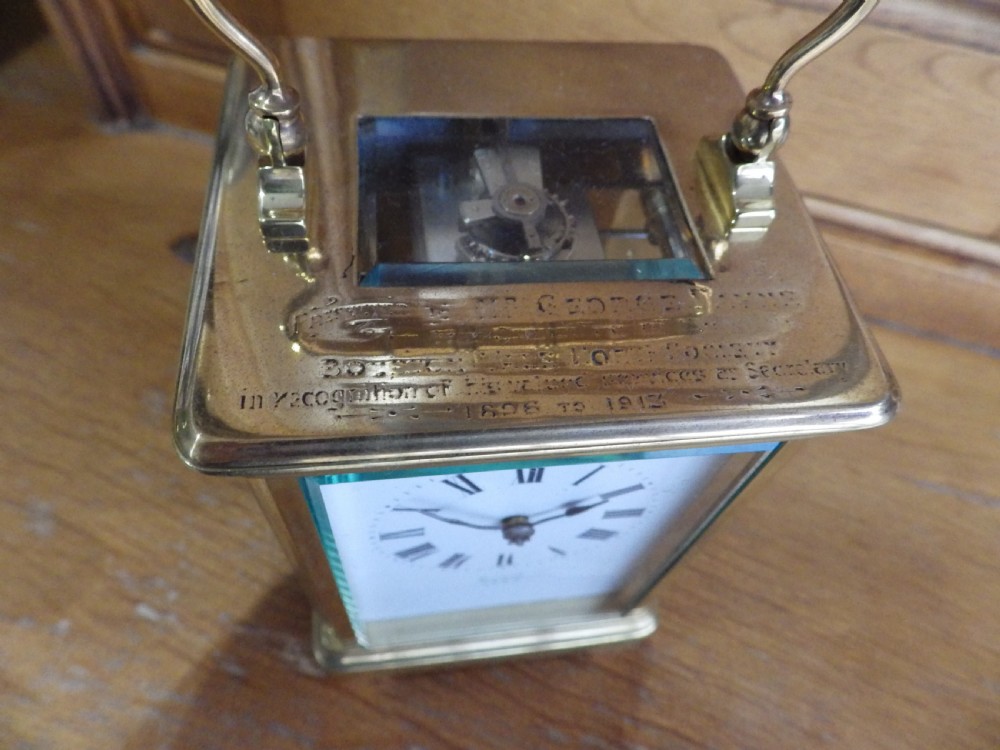 A rectangular Victorian brass carriage clock featuring a top carrying handle, glass side panels, and a white dial with black Roman numerals signed Mappin & Webb Ltd. View VI