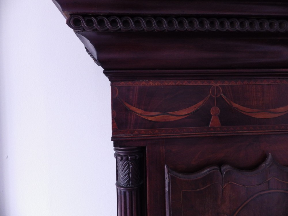 A late 18th-century Georgian mahogany longcase clock featuring a swan-neck pediment and an arched painted dial with moon phase function. View V