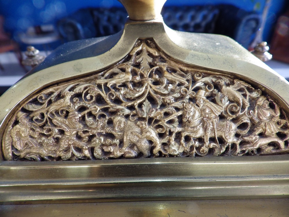An 1870s French solid brass mantel clock featuring ornate filigree, corner columns, a finial cresting, and a Roman numeral dial. View III